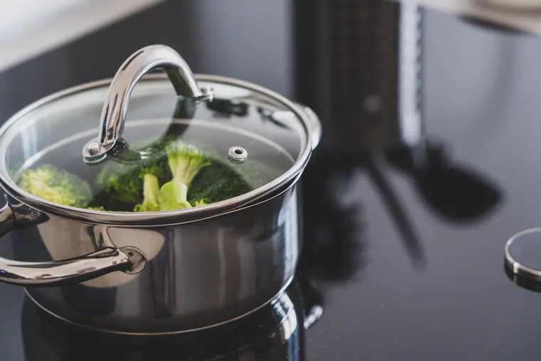 Brocoli qui cuit à la vapeur sous le couvercle en verre d’une marmite en inox